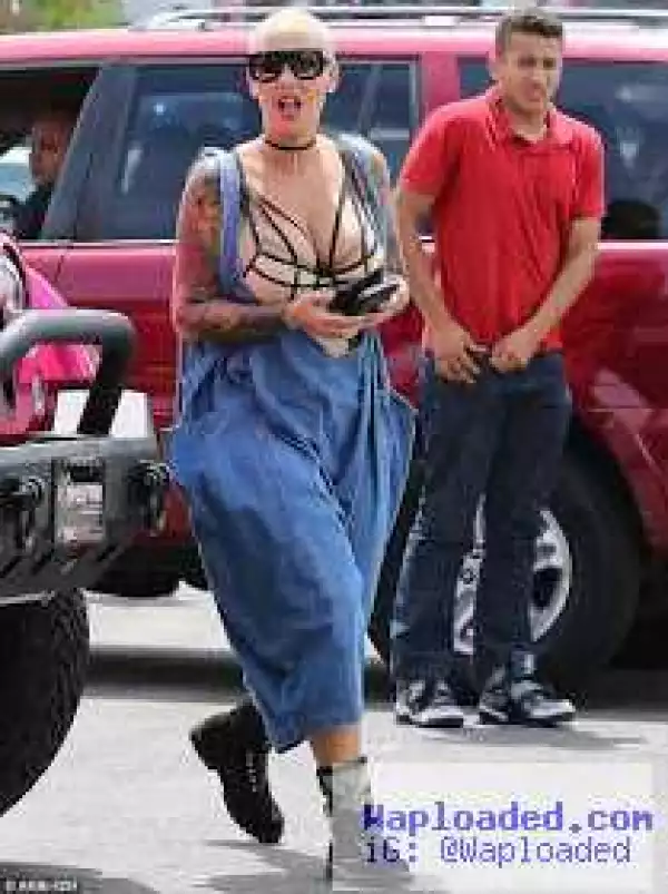 Amber Rose puts her massive boobs on display wearing baggy overalls